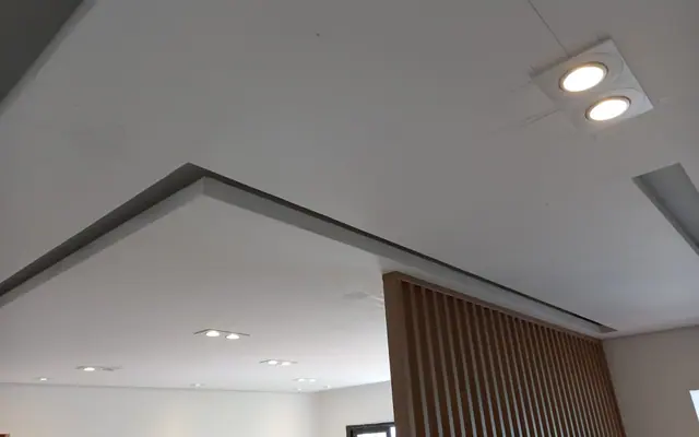 Sanca linear de drywall junto a painel ripado em ambiente residencial